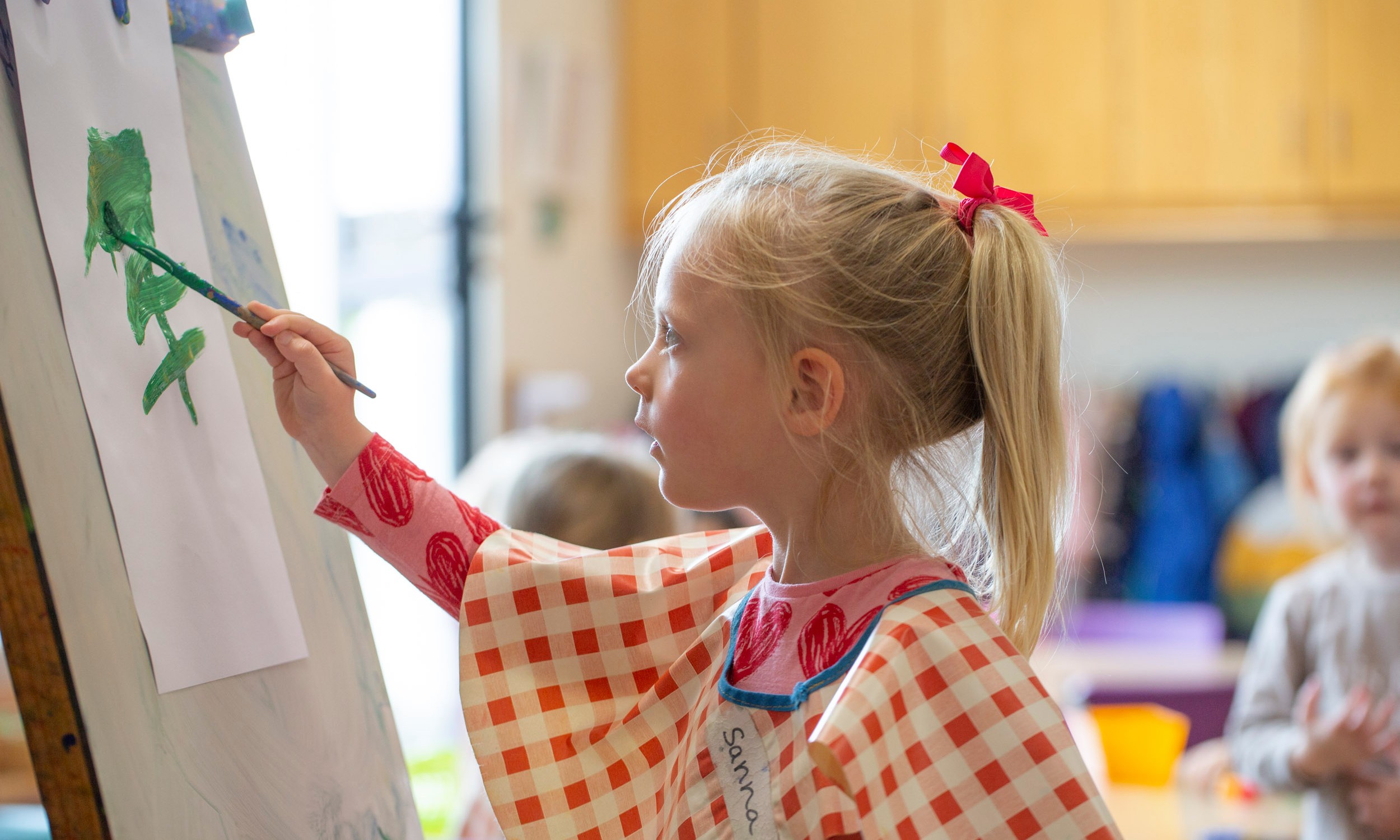 young girl painting in classroom